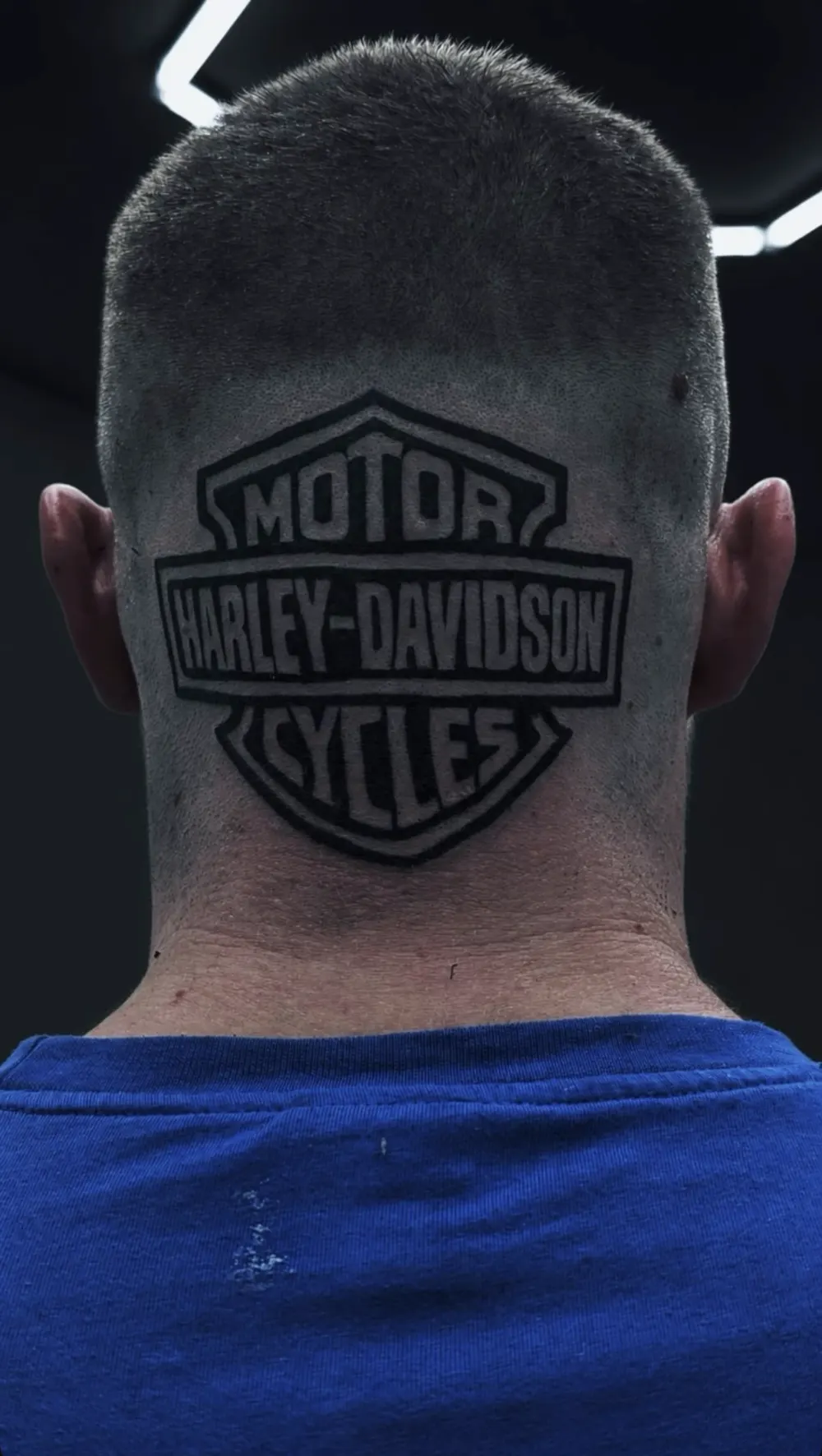 Harley-Davidson-Logo als Blackwork-Tattoo am Hinterkopf